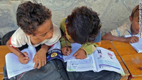 Yemeni children attend class outdoors in a heavily-damaged school on the first day of the new academic year in Yemen&#39;s war-torn western province of Hodeida on Monday. 