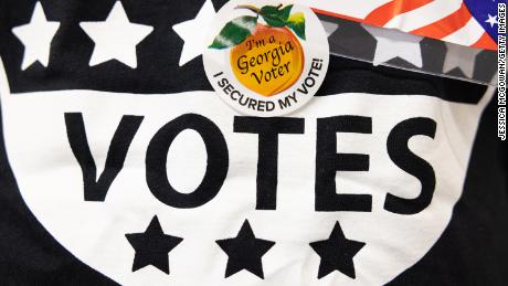 A poll worker wears an &quot;I&#39;m a Georgia Voter&quot; sticker at the Metropolitan Library polling location on May 24, 2022 in Atlanta, Georgia. Voters across Georgia will be voting on several positions, including U.S. Senate seats, Georgia Secretary of State, and the Governor position.