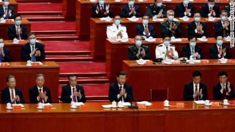 Chinese leader Xi Jinping and other officials applaud during the closing ceremony of the party&#39;s 20th National Congress, while the seat occupied by former leader Hu Jintao remains empty, following his unexpected exit from the room.