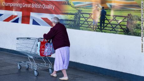A customer pushes a shopping cart into an Aldi supermarket in Sheffield on Saturday, Oct. 15.