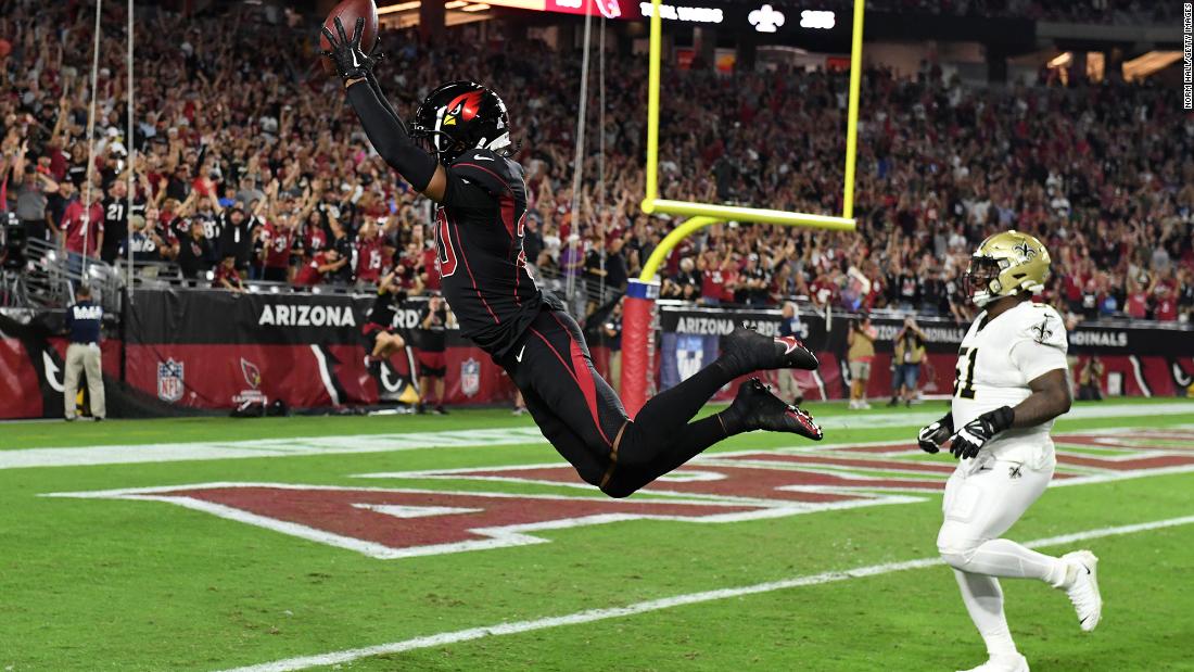 Arizona Cardinals cornerback Marco Wilson leaps into the end zone as he returns an interception for a touchdown during a Thursday Night Football football game against the New Orleans Saints. The Arizona defense scored touchdowns on two pick-sixes late in the first half.