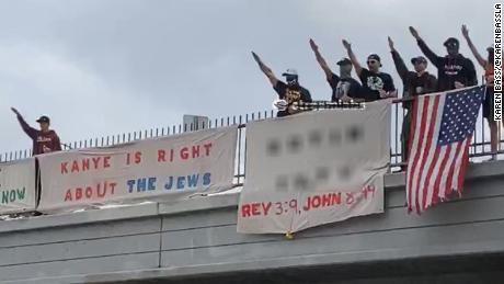 A photograph shared on the verified campaign Twitter account of Los Angeles mayoral candidate Karen Bass shows a group of demonstrators with banners showing support for rapper Kanye West&#39;s recent antisemitic remarks on a Los Angeles freeway overpass Saturday. CNN has blurred a portion of the image that included a reference to a website with antisemitic content.