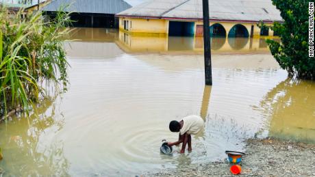 A child is pictured doing her dishes in floodwater in Odi, in Nigeria&#39;s southern Bayelsa State, on Tuesday.