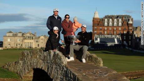Fox poses with the Alfred Dunhill Links Championship trophy with mother Adele Fox, father Grant Fox, wife Anneke Fox and their daughter Isabel Fox on the Swilcan Bridge at St. Andrews.