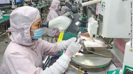 A woman inspects the quality of a chip at a manufacturer of IC encapsulation in Nantong in east China&#39;s Jiangsu province Friday, Sept. 16, 2022.