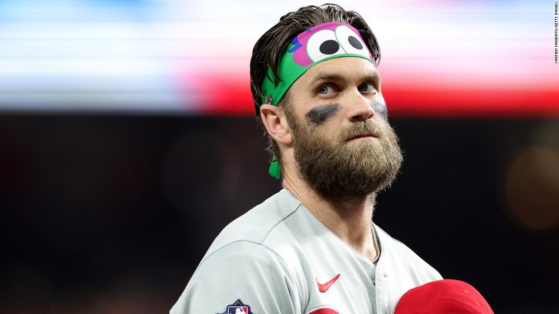 Harper wears &lt;a href=&quot;https://www.mlb.com/phillies/fans/phillie-phanatic&quot; target=&quot;_blank&quot;&gt;Phillie Phanatic&lt;/a&gt; gear as he stands for the National Anthem on Friday.