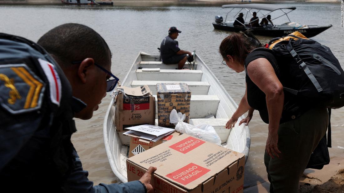 Election officials and military police officers transport electronic ballot boxes in Bela Vista do Jaraqui, Brazil, on October 29.