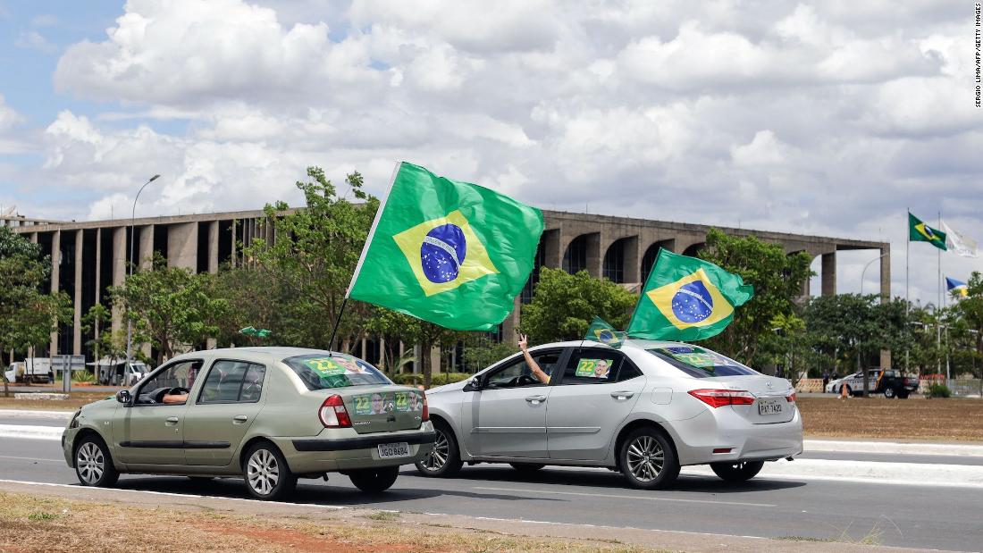 Supporters of incumbent President Jair Bolsonaro wave Brazilian flags in Brasília on October 30.