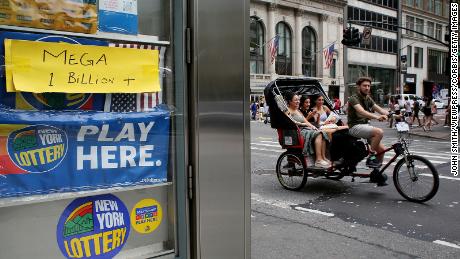 A pedicab rides past advertisements for the Powerball lottery on July 29, 2022 in New York. 