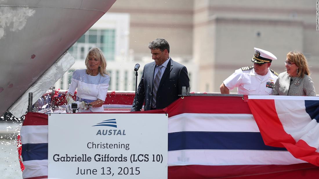 Jill Biden, wife of Biden, smashes a champagne bottle on the bow of a US Navy vessel that was being named in Giffords&#39; honor in June 2015. Giffords and Kelly are on the right.