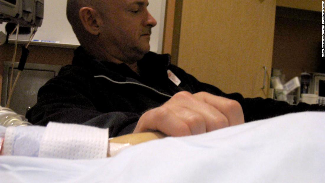 Giffords&#39; husband, Mark Kelly, holds his wife&#39;s hand in her hospital room on January 9, 2011.