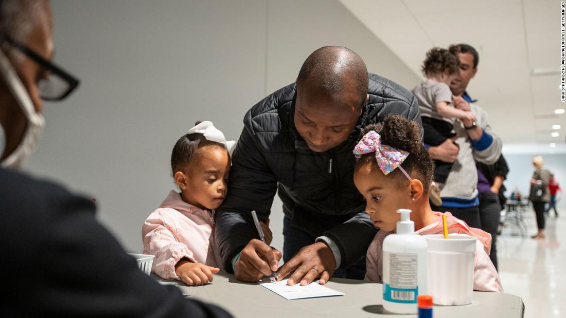 Milwaukee Mayor Cavalier Johnson signs his ballot envelope with his twin daughters on November 5.