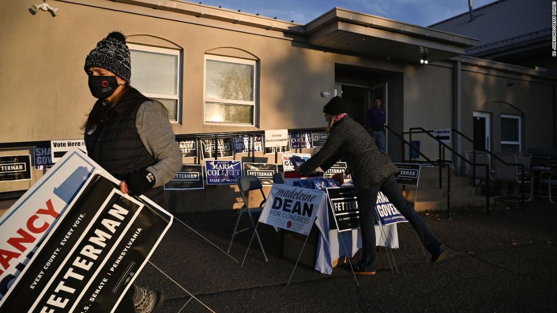 People move campaign signs outside a polling station in Bryn Athyn, Pennsylvania, on Election Day.