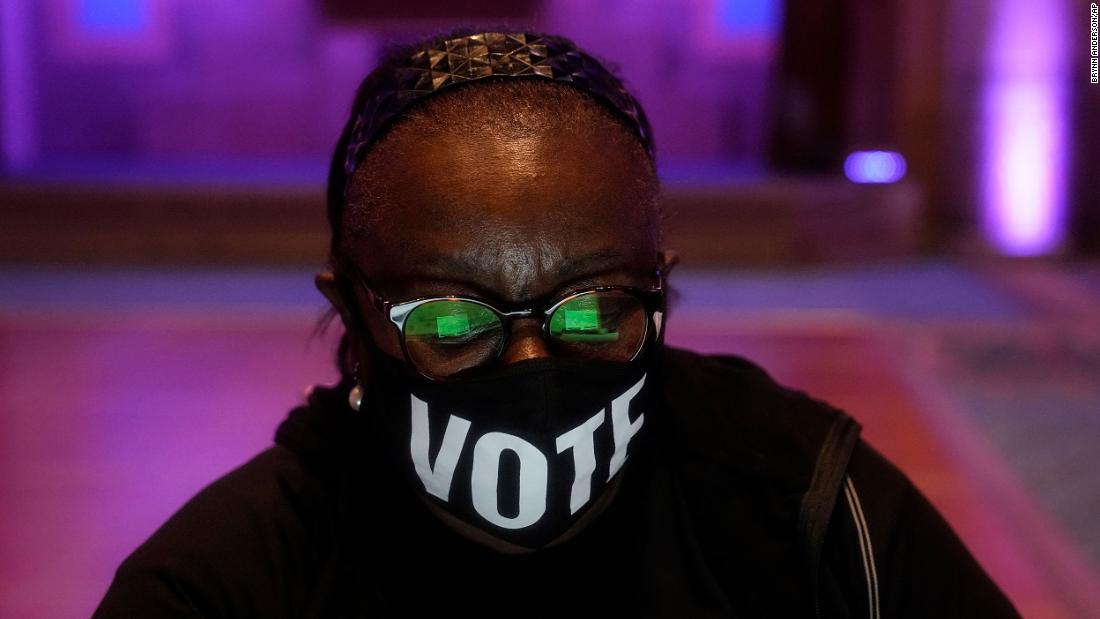 A poll worker in Atlanta wears a &quot;vote&quot; mask while checking in voters on Election Day.