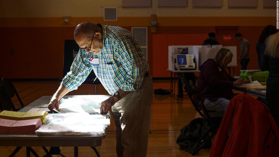 Poll worker Ron Betz grabs a provisional ballot for a voter at a polling location in Columbus, Ohio.