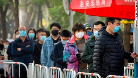People in face masks wait in line for Covid-19 tests in Beijing, China, on November 10.