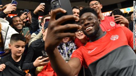 Canada midfielder Alphonso Davies -- here signing autographs and taking photos with fans -- helped lead his country to the World Cup.