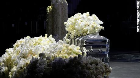 Takeoff&#39;s flower-covered casket sits at the foot of the stage during the service.