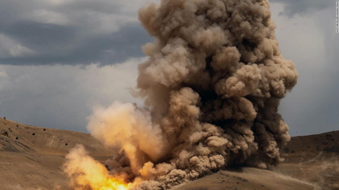 A solid rocket booster motor fires up on July 21 at Northrop Grumman&#39;s test facility in Promontory, Utah. The booster motor, positioned horizontally for the ground test, fired for a little over two minutes and produced 3.6 million pounds of thrust, according to NASA.