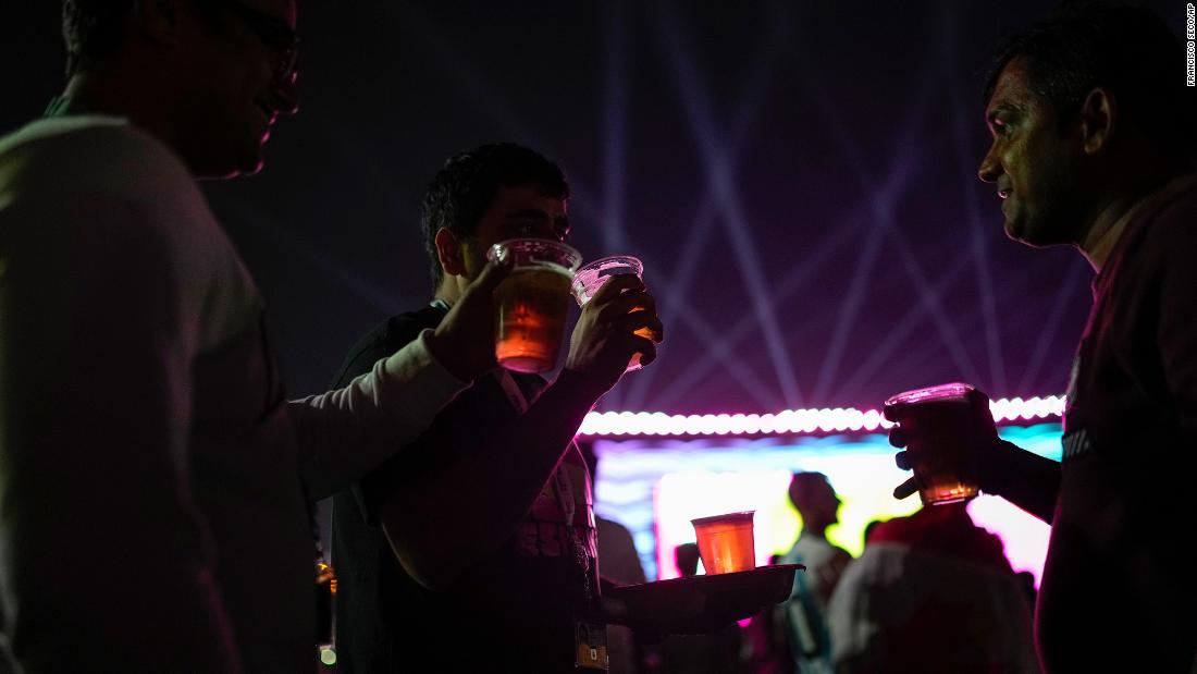 Fans drink beer as they watch the match from a fan zone in Doha. &lt;a href=&quot;https://www.cnn.com/2022/11/18/football/qatar-world-cup-beer-stadium-spt-intl/index.html&quot; target=&quot;_blank&quot;&gt;No alcohol is being sold&lt;/a&gt; inside the stadiums during the World Cup. Qatar tightly regulates alcohol sales and usage.