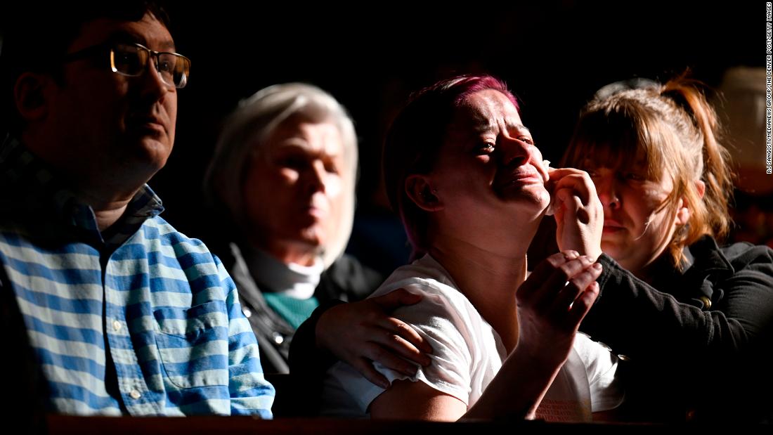 Jessi Hazelward wipes a tear from her friend Amanda Grueschow&#39;s face during a vigil in Colorado Springs on Sunday.