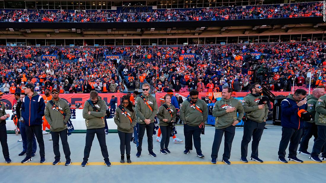 Denver Broncos staff members and fans observe a moment of silence Sunday for the shooting victims.