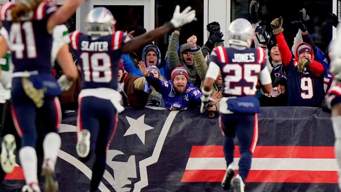New England Patriots fans celebrate as cornerback Marcus Jones scores an 84-yard punt return in the final 30 seconds of the game to give the Pats a 10-3 win over division rivals, the New York Jets.
