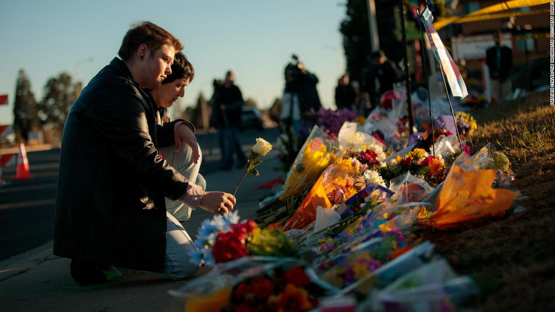 Ren Kurgis, left, and Jessie Pacheco leave flowers Sunday at the growing memorial in Colorado Springs.