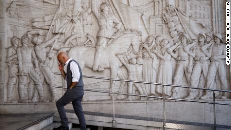 FILE PHOTO: A man walks past a bas-relief depicting fascist leader Benito Mussolini in the EUR neighbourhood of Rome, Italy, known for its fascist architecture, October 19, 2022. REUTERS/Guglielmo Mangiapane/File Photo