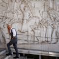 FILE PHOTO: A man walks past a bas-relief depicting fascist leader Benito Mussolini in the EUR neighbourhood of Rome, Italy, known for its fascist architecture, October 19, 2022. REUTERS/Guglielmo Mangiapane/File Photo