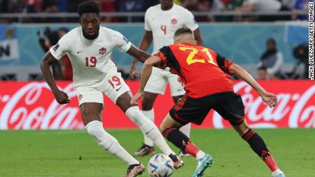 Canada forward #19 Alphonso Davies fights for the ball with Belgium defender Timothy Castagne.