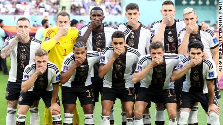 Germany&#39;s players pose with their hands covering their mouths prior to their World Cup game against Japan.