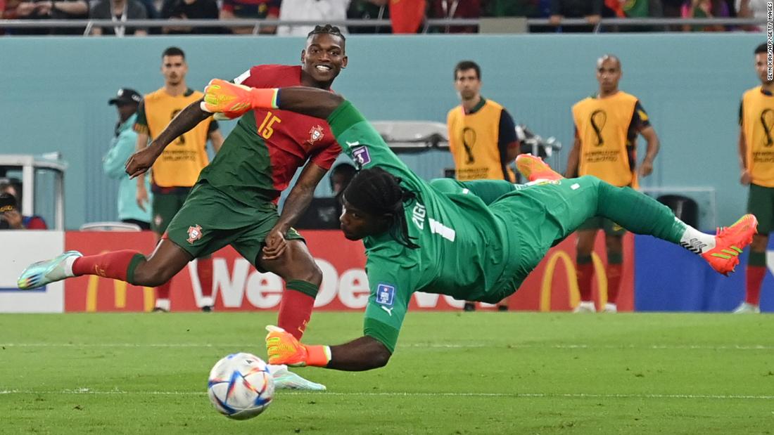 Rafael Leão smiles as his shot goes by Ghana goalkeeper Lawrence Ati-Zigi for Portugal&#39;s third goal.