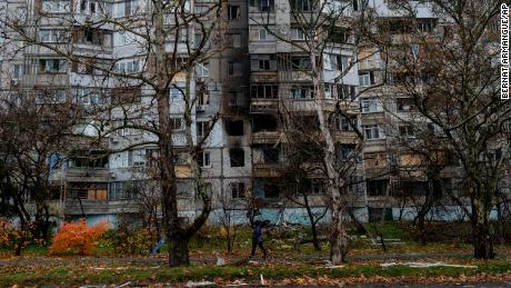 A woman walks past a recently damaged building due to a Russian strike in Kherson, southern Ukraine, Friday, Nov. 25, 2022. A barrage of missiles struck the recently liberated city of Kherson for the second day Friday in a marked escalation of attacks since Russia withdrew from the city two weeks ago following an eight-month occupation.