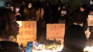 Demonstranten stehen am Samstag, den 26. November 2022, an Protestschildern in Shanghai, China.