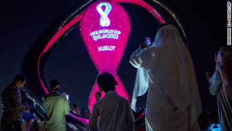 People take photos with the official FIFA World Cup Countdown Clock on Doha&#39;s corniche, in Qatar, on October 14.