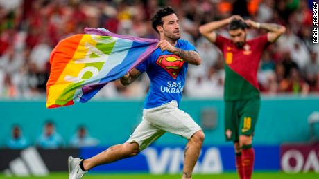 A pitch invader runs across the field with a rainbow flag during the 2022 World Cup Group H match between Portugal and Uruguay at the Lusail Stadium in Lusail, Qatar on Monday, November 28.