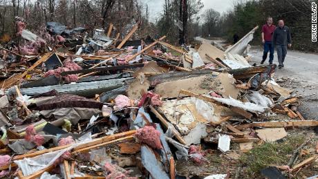 People walk through an area of destoryed structures in Flatwood, Ala. on Wednesday, Nov. 30, 2022. Tornadoes damaged numerous homes, destroyed a fire station, briefly trapped people in a grocery store and ripped the roof off an apartment complex in Mississippi and Alabama. (AP Photo/Butch Dill)