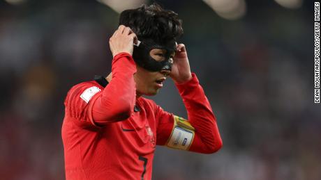 Son Heung-min adjusts his mask during South Korea&#39;s game against Portugal at the 2022 World Cup.
