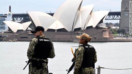 Australia&#39;s landmark Opera House is seen past military personnel on board the US Navys USS Tripoli (LHA-7) amphibious assault ship while docked at fleet base in Sydney on November 4, 2022. - The USS Tripoli and her 1,200-strong crew made a port call as part of routine operations in the Indo-Pacific.