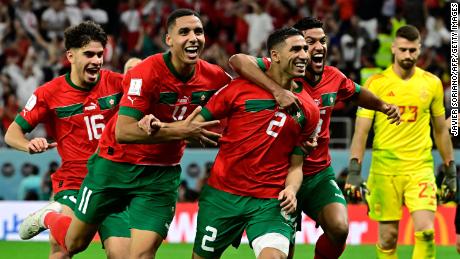 Morocco&#39;s Achraf Hakim celebrates with teammates after converting the last penalty during the penalty shoot-out against Spain.