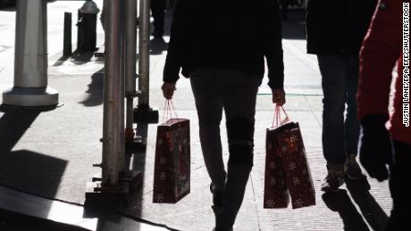 A person carrying shopping bags in New York, New York, on December 14. Consumer sentiment improved in December as inflation eased, but Americans remain downbeat about the overall economy, new data out of the University of Michigan showed.