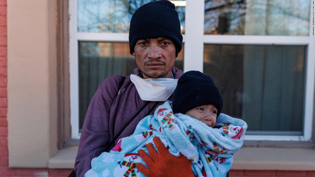 Carlos Pavon Flores, with 1-year-old daughter Esther, stands outside a shelter that turned them away for not having bus tickets in downtown El Paso on December 14.