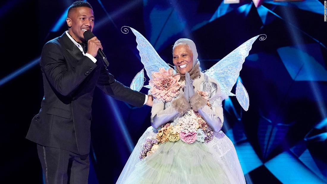 Host Nick Cannon and Warwick appear on stage after Warwick was unmasked during an episode of &quot;The Masked Singer&quot; in 2020.