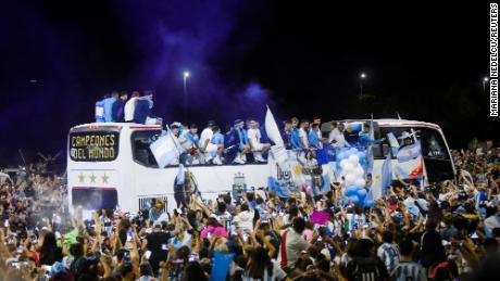 The Argentina football team on a bus in Buenos Aires on December 20, surrounded by cheering fans.