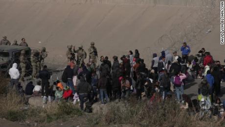 A group of migrants are waiting on the US side of the Rio Grande as the Texas National Guard blocked access to parts of the border with barbed wire and vehicles as seen from Ciudad Juarez, Mexico con 20 December 2022.