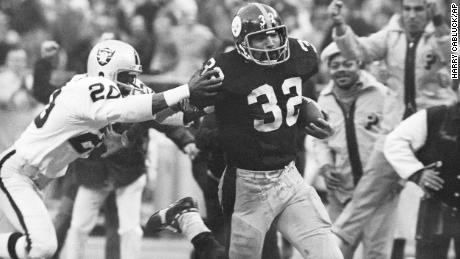 Harris (32) eludes a tackle by Oakland Raiders&#39; Jimmy Warren as he runs 42-yards for a touchdown after catching a deflected pass during an AFC Divisional NFL football playoff game in Pittsburgh on Dec. 23, 1972. 