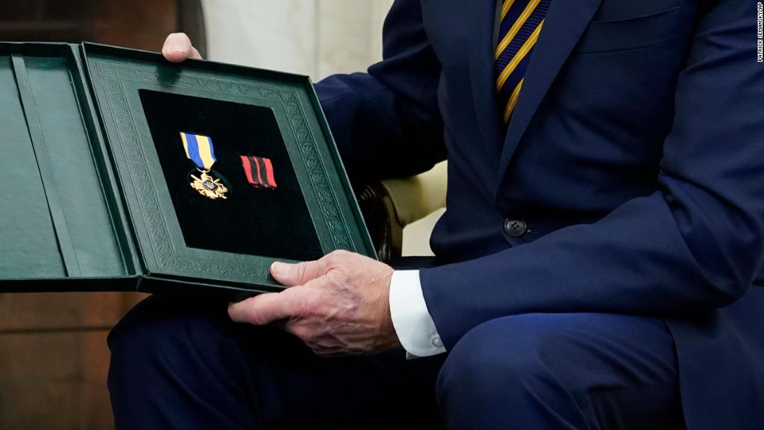 Biden holds the Cross of Combat Merit. &quot;He&#39;s very brave,&quot; Zelensky said of the soldier. &quot;And he said give it to very brave President, and I want to give you, that is a cross for military merit.&quot;