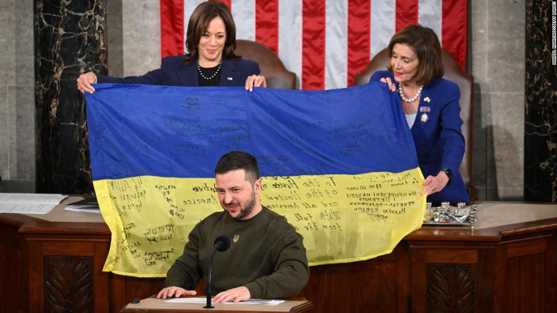 President Volodymyr Zelensky addresses Congress as Rep. Nancy Pelosi and Vice President Kamala Harris hold up a Ukrainian national flag signed by Ukrainian soldiers at the Capitol in Washington on Wednesday, December 21.