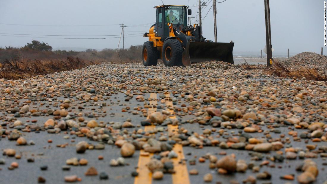 Stones are removed from a road in Westport, Massachusetts, after a storm surge made landfall, flooding many coastal areas on December 23. 